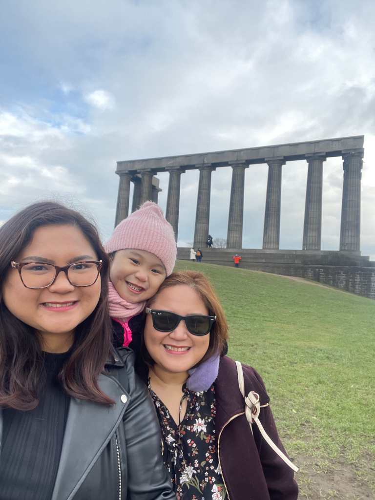 Two women and a child are seen happily posing with the magnificent National Monument in the background.