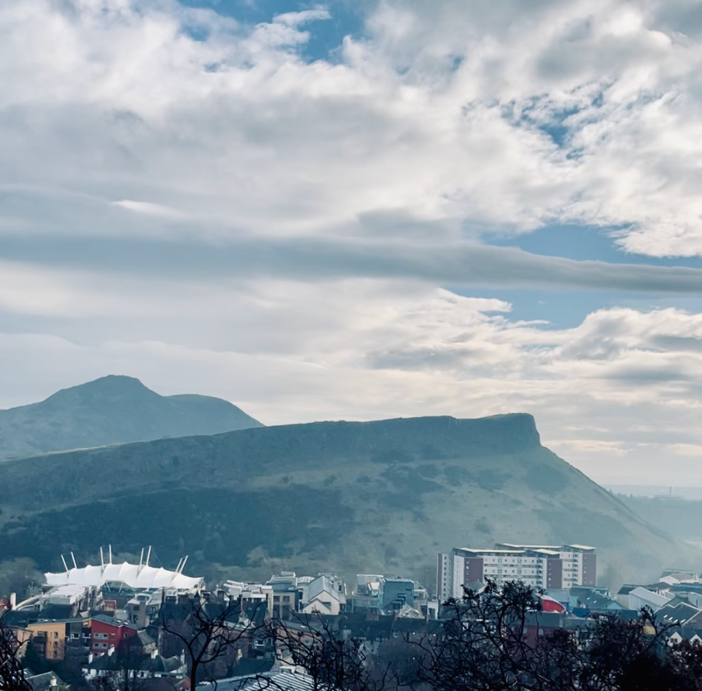 Scenic view from Calton Hill showcasing Arthur's Seat, an ancient volcano, and the distinctive architecture of Dynamic Earth.