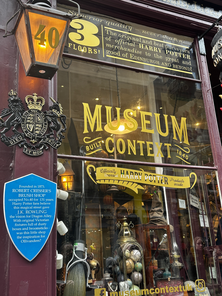 Vibrant window display at the Museum Context on Victoria Street, Edinburgh, featuring an array of Harry Potter merchandise and themed items, capturing the magic and allure of the wizarding world.