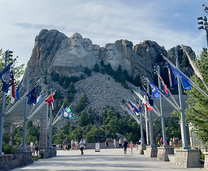 A photo capturing the Avenue of Flags, a pathway lined with flags from various states, guiding the way to the Grand View Terrace. The flags, proudly representing different states, create a vibrant display on both sides of the avenue, with Mount Rushmore as the backdrop. 
