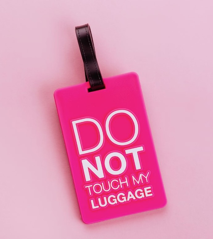 Bright pink luggage tag with a black strap that reads “DO NOT TOUCH MY LUGGAGE” in bold letters. A fun and assertive travel stocking stuffer for frequent flyers.