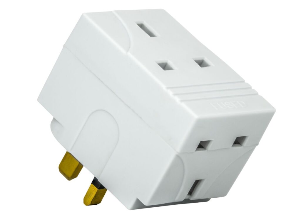 White fused power adapter with three rectangular prongs, designed for UK-style outlets. A must-have travel stocking stuffer for international power compatibility.
