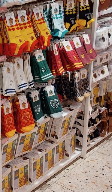 Colourful rows of Harry Potter-themed socks in house colours for Gryffindor, Slytherin, Ravenclaw, and Hufflepuff, ideal as small, cozy stocking stuffers.